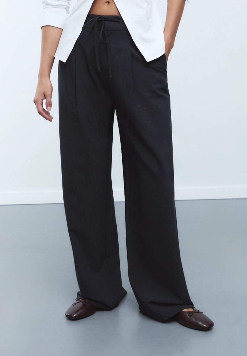 Брюки со складками, шнурками и полосками