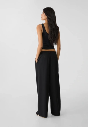 Брюки свободного кроя в строгом стиле с защипами- Заказать в России